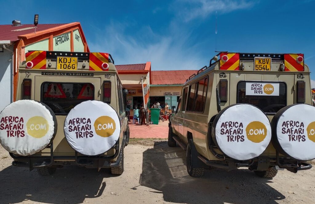 Två av Afrika Safari Resors egna safari-jeepar utanför ett hus i Afrika