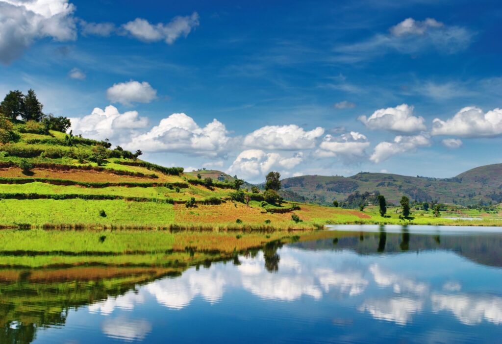 Bunyonyisjön i Uganda med blå himmel och gröna kullar i fonden