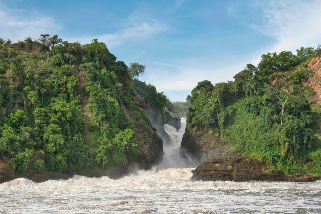 Murchison Falls vattenfall som faller genom ravinen med gröna träd runt