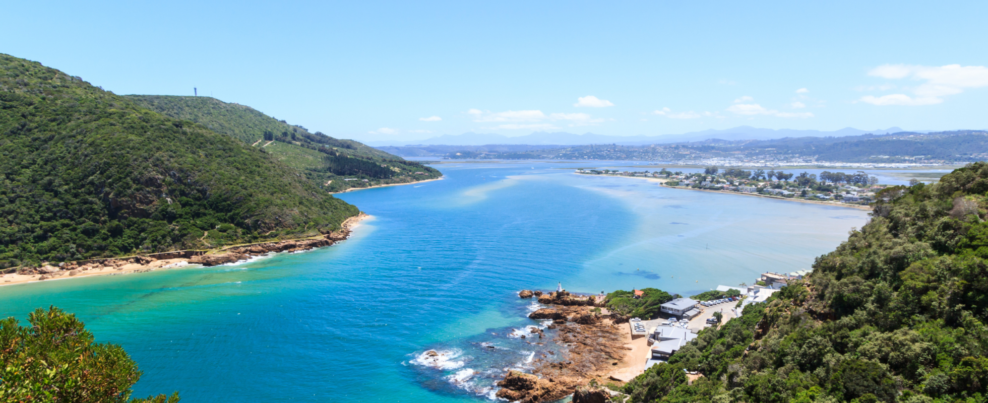 Gröna kullar och blått hav vid Garden Route i Sydafrika