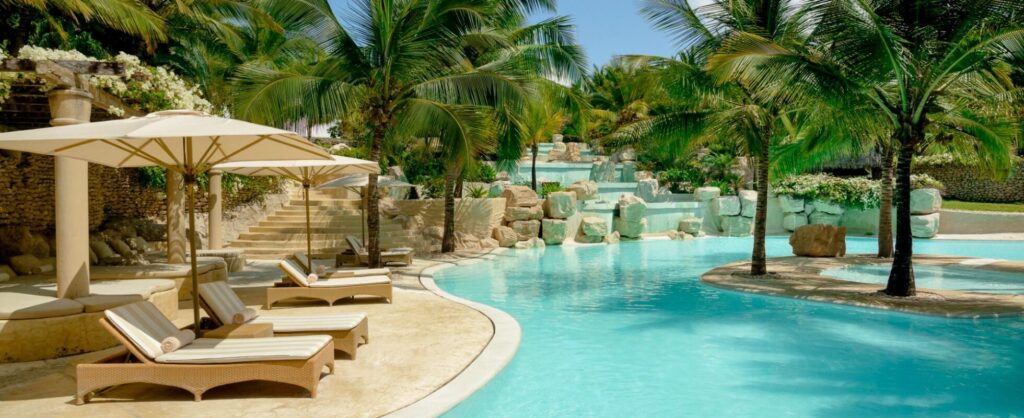 Pool med solstolar och parasoll på Swahili Beach Resort