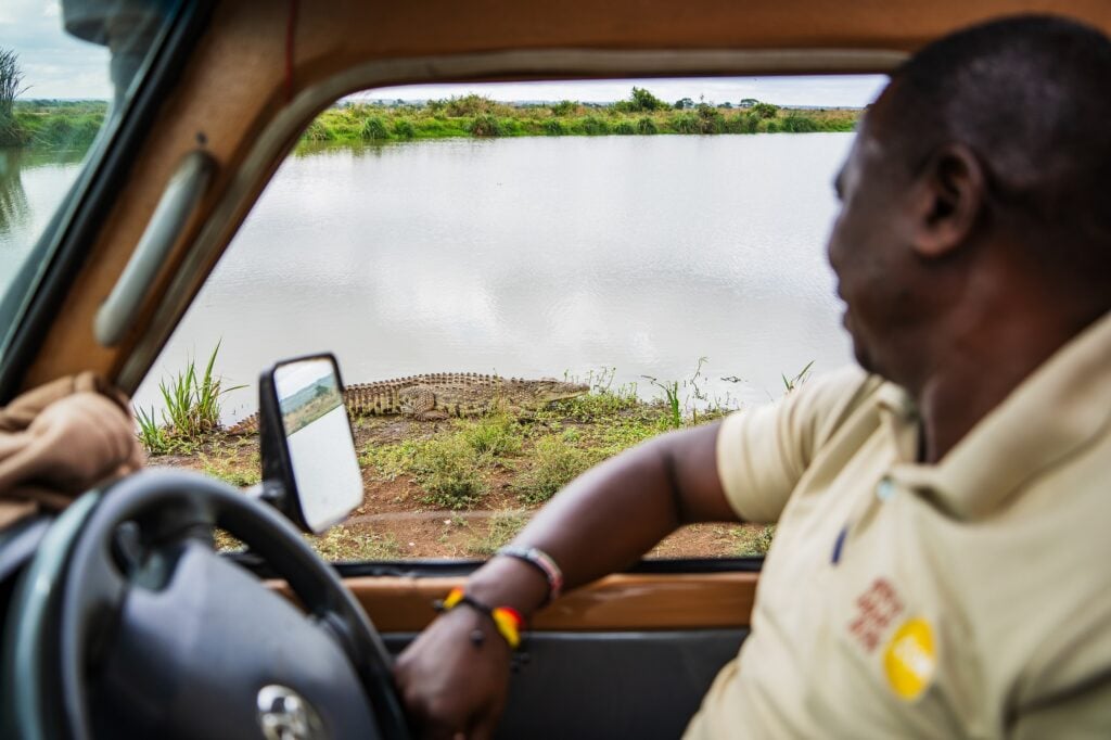 Safari-jeep med förare som tittar ut mot sjö