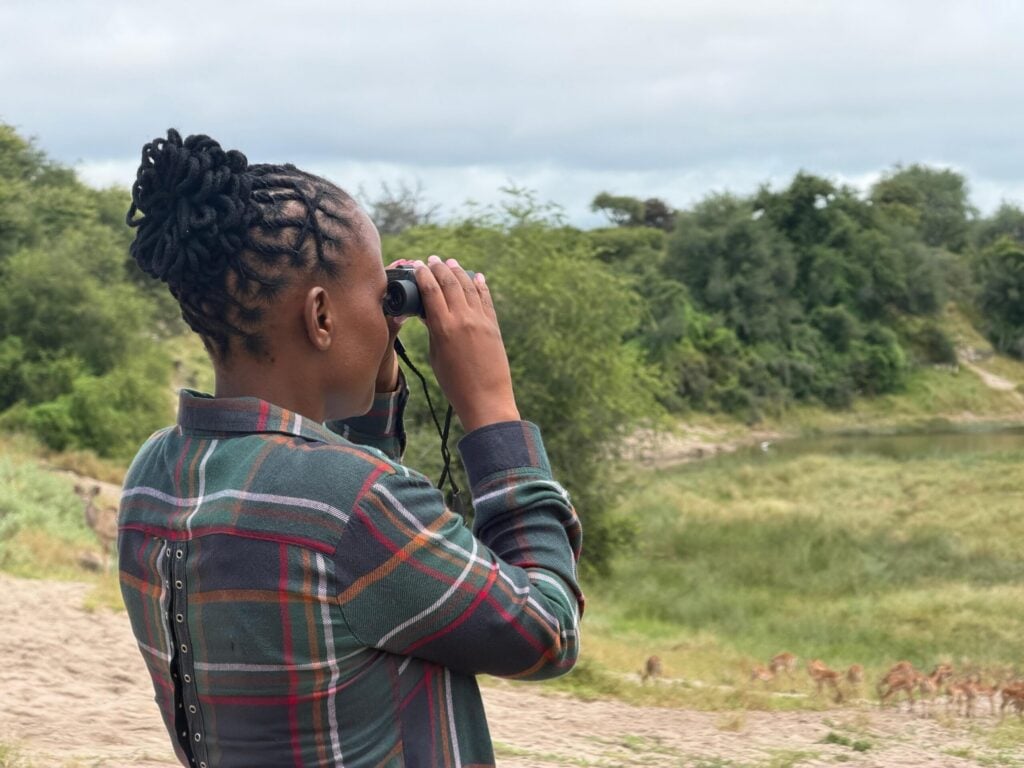 Safarispecialist i Botswana står och håller en kikare