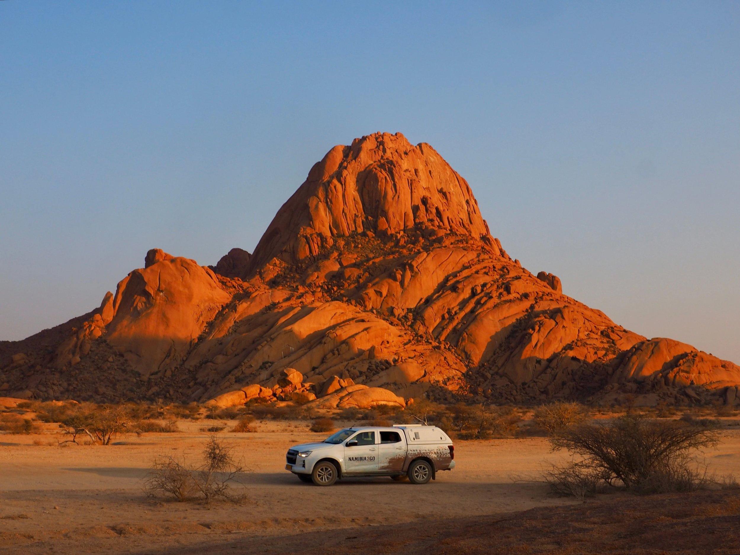 Safaribil parkerad nedanför Spitzkoppe i solnedgången